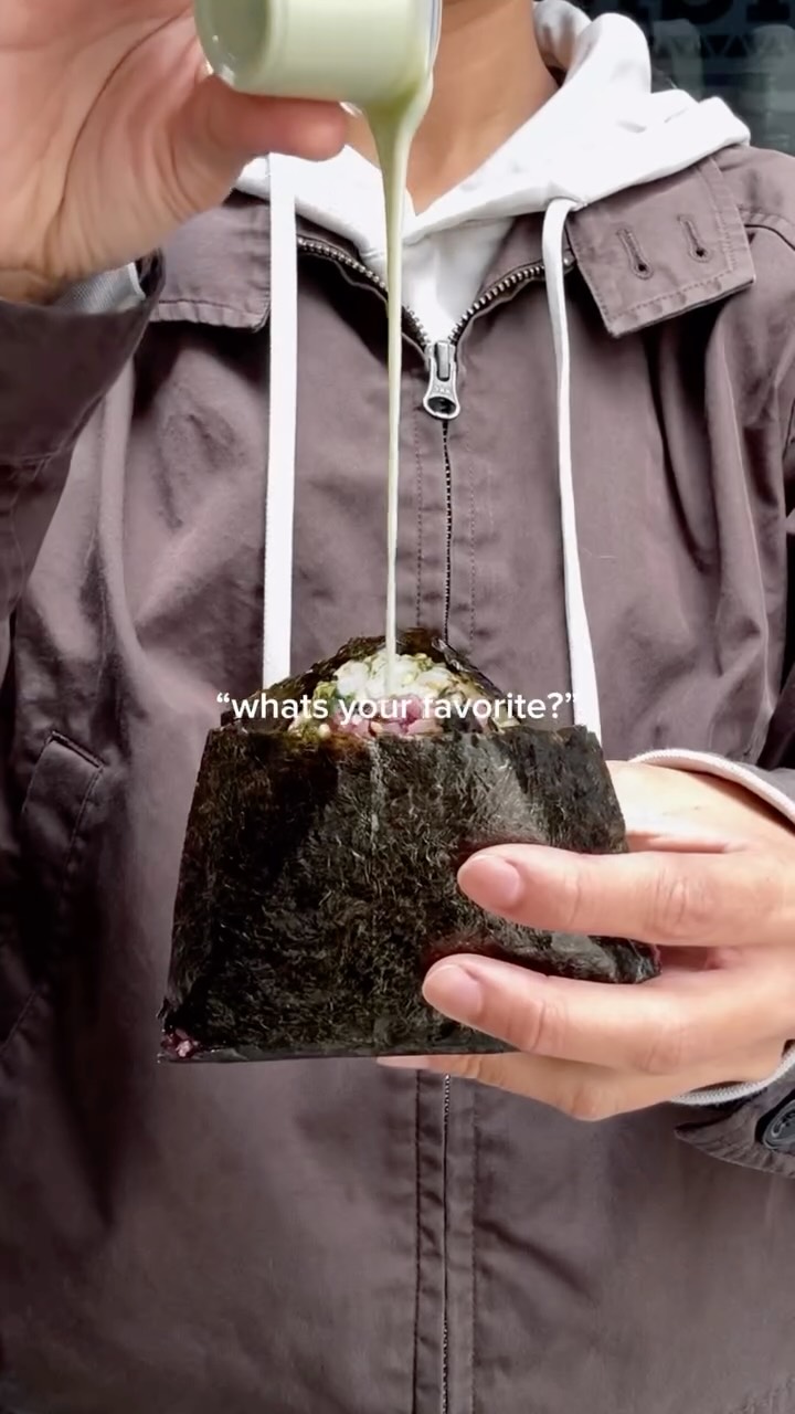 Matcha cream poured over a chunky onigiri